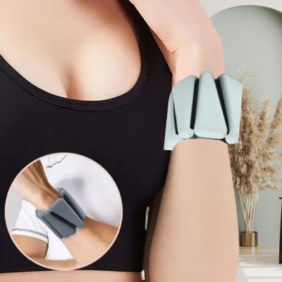 Premier plan, buste de femme, bras au poignet, un bracelet lesté triangle gris
