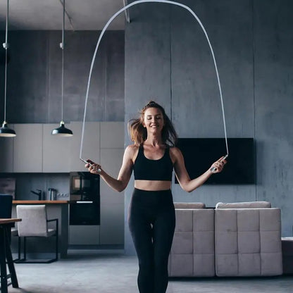 Appartement sombre femme face saute à la corde au milieu du salon