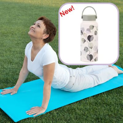  Femme mature en posture cobra sur tapis de yoga, avec visuel de gourde en verre à motif feuilles – hydratation bien-être après 50 ans