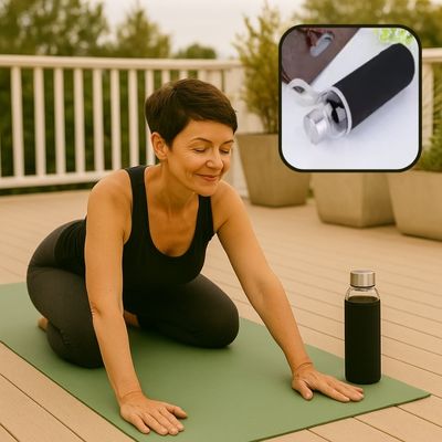  Femme de 50 ans en posture active dans son salon, gourde noire posée à côté d’elle sur le tapis de gym – vitalité et énergie retrouvée